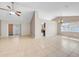 Bright living room with tile flooring, neutral walls, ceiling fan, and sliding glass door to the outside at 1969 Wolf Laurel Dr, Sun City Center, FL 33573