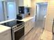 Modern kitchen with stainless steel appliances, white cabinets, and an adjacent laundry area, combining style and functionality at 205 Park Ridge Ave, Temple Terrace, FL 33617