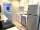 Bright kitchen with stainless steel appliances, white cabinets, and a view into the laundry area, offering convenience and style at 205 Park Ridge Ave, Temple Terrace, FL 33617
