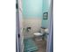 Powder bath with wainscoting, turquoise paint, modern fixtures, and a blue rug at 2217 5Th E St, Palmetto, FL 34221