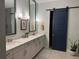 A modern bathroom features a long double sink vanity, a sliding door, and neutral-colored walls at 2217 5Th E St, Palmetto, FL 34221