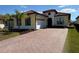 Beautiful yellow house featuring a brick driveway, 2-car garage, and well-maintained landscaping with a palm tree at 2217 5Th E St, Palmetto, FL 34221