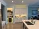 Stylish kitchen boasts custom white cabinetry, wine storage, quartz countertops, and stainless steel appliances at 2217 5Th E St, Palmetto, FL 34221