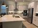 Modern kitchen featuring stainless steel appliances, white cabinets, a center island, and elegant pendant lighting at 2217 5Th E St, Palmetto, FL 34221