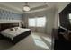 A naturally lit primary bedroom with white carpet, tray ceiling, and an accent wall with palm leaf wallpaper at 2217 5Th E St, Palmetto, FL 34221