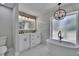 Modern bathroom featuring a standalone tub, double vanity, designer mirror and light fixtures at 3004 Rolling Acres Pl, Valrico, FL 33596