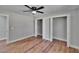 This bedroom features wood-look flooring, neutral colors, and open closets at 3004 Rolling Acres Pl, Valrico, FL 33596