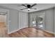 The bedroom has wood-look floors, a ceiling fan, closet, and French doors at 3004 Rolling Acres Pl, Valrico, FL 33596