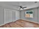Bright bedroom features wood-look flooring, a ceiling fan, and closet storage at 3004 Rolling Acres Pl, Valrico, FL 33596