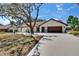 Single-story home with brown roof and attached garage, surrounded by mature trees and a concrete driveway at 3004 Rolling Acres Pl, Valrico, FL 33596