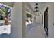 Exterior view of the home's covered walkway, featuring white columns, accent lighting, and brick tiling at 3004 Rolling Acres Pl, Valrico, FL 33596