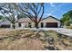 Well-kept single-story home with a brown roof, attached garage, and landscaping at 3004 Rolling Acres Pl, Valrico, FL 33596