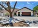 Exterior view of a home with a 2 car garage, a brown roof, and updated landscaping at 3004 Rolling Acres Pl, Valrico, FL 33596