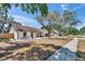 Inviting single-story home with manicured front lawn, white brick, mature trees, and a sidewalk at 3004 Rolling Acres Pl, Valrico, FL 33596