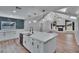 Island kitchen featuring quartz counters, farmhouse sink, and modern backsplash at 3004 Rolling Acres Pl, Valrico, FL 33596