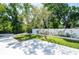 Fenced backyard with manicured lawn, decorative tree, stone feature, and gazebo nearby at 3302 W Caracas St, Tampa, FL 33614