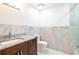 Bathroom featuring marble tile, a vanity with granite countertop, and modern fixtures at 3302 W Caracas St, Tampa, FL 33614
