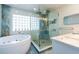 Luxurious bathroom featuring a soaking tub and glass-enclosed shower at 3302 W Caracas St, Tampa, FL 33614