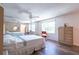 Bedroom with wood-look flooring, ceiling fan, natural light, and mirrored closet at 3302 W Caracas St, Tampa, FL 33614