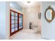 Foyer featuring double wood-framed glass doors, tile floors, modern lighting, and a mirror at 3302 W Caracas St, Tampa, FL 33614