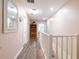 Light-filled hallway with wood floors, pink walls and white trim and banister at 3302 W Caracas St, Tampa, FL 33614
