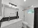 Bathroom featuring dual vanity, modern lighting, and a beautifully tiled shower at 3309 Rock Royal Dr, Holiday, FL 34691
