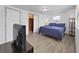 Cozy bedroom featuring hardwood floors, closet, and a comfortable bed with side table at 3309 Rock Royal Dr, Holiday, FL 34691