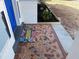 Close-up of a colorful welcome mat and a patterned, mosaic tile front entrance at 3309 Rock Royal Dr, Holiday, FL 34691
