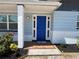 Charming front entrance with a vibrant blue door, mosaic tile, and newly landscaped flower beds at 3309 Rock Royal Dr, Holiday, FL 34691