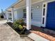 Charming front porch with a blue door, colorful mosaic tile, and newly landscaped flower beds at 3309 Rock Royal Dr, Holiday, FL 34691