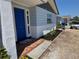 Charming front entrance with a vibrant blue door, mosaic tile, and newly landscaped flower beds at 3309 Rock Royal Dr, Holiday, FL 34691