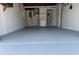 Spacious garage with painted floor, utilities, and access to a bathroom at 3309 Rock Royal Dr, Holiday, FL 34691