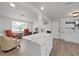 Bright open kitchen featuring white cabinetry, island, and view into living room at 3309 Rock Royal Dr, Holiday, FL 34691