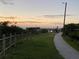 Paved walking path leading to a pier, offering scenic views and a tranquil atmosphere for strolls at 3309 Rock Royal Dr, Holiday, FL 34691