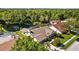 Aerial view showcasing the home's screened pool, pond, and manicured lawn in a lush, wooded setting at 3579 Landmark Trl, Palm Harbor, FL 34684