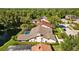 Aerial view of a home with a screened pool, a pond, and lush landscaping in a desirable neighborhood at 3579 Landmark Trl, Palm Harbor, FL 34684