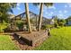 A backyard featuring a screened enclosure, landscaping, and two palm trees at 3579 Landmark Trl, Palm Harbor, FL 34684