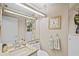 This half bathroom features a decorative mirror, granite countertops, and coordinated hand towels for a refined look at 3579 Landmark Trl, Palm Harbor, FL 34684