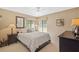 Cozy bedroom bathed in natural light from three windows with ceiling fan and a dark furniture set at 3579 Landmark Trl, Palm Harbor, FL 34684