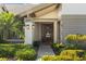 Inviting entryway with manicured landscaping leading to a stylish front door and well-lit address plaque at 3579 Landmark Trl, Palm Harbor, FL 34684