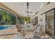 Screened-in patio with comfortable seating and a beautiful view of the pool at 3579 Landmark Trl, Palm Harbor, FL 34684