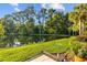 Picturesque pond view featuring lush landscaping with mature trees at 3579 Landmark Trl, Palm Harbor, FL 34684