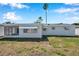 The backyard of this home with an awning-covered window and screened-in porch exudes peaceful relaxation at 3624 Hendrix St, New Port Richey, FL 34652