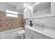 Bright bathroom featuring tiled walls, a modern vanity, and a bathtub for a comfortable and stylish experience at 3624 Hendrix St, New Port Richey, FL 34652