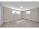 This neutral bedroom features wood-look flooring and two windows at 3624 Hendrix St, New Port Richey, FL 34652