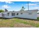 Exterior view of a home with awning-covered windows, a screened-in porch and a well-kept lawn at 3624 Hendrix St, New Port Richey, FL 34652