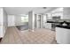 Open-concept kitchen with white cabinets, black counters, and view to the living area at 3624 Hendrix St, New Port Richey, FL 34652