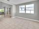 Bright living room features a large window and neutral tile flooring at 3624 Hendrix St, New Port Richey, FL 34652