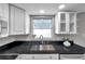 Close-up of a kitchen sink with black granite countertop and a window at 3624 Hendrix St, New Port Richey, FL 34652