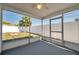 Screened patio with gray floor featuring a view of the backyard with a white fence for relaxed outdoor enjoyment at 3624 Hendrix St, New Port Richey, FL 34652